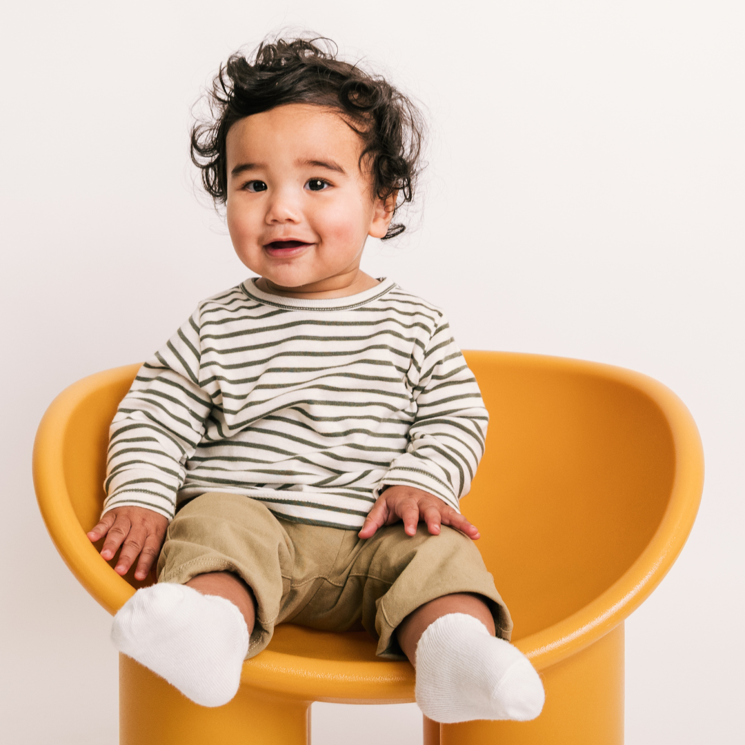 Happy child sitting in a yellow chair